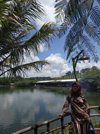 Sculpture by river against sky