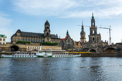 View of buildings and river against cloudy sky