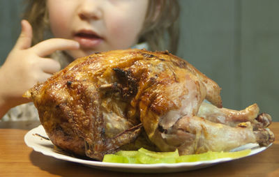 Close-up of person eating meat in plate