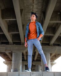 Portrait of young man standing against building