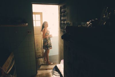 Woman standing in corridor at home