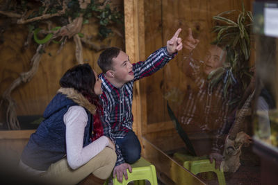 Young man with down syndrome and young woman visiting reptile exhibition