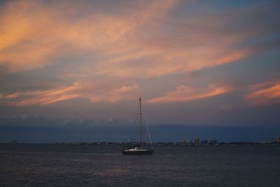 Sailboat sailing on sea against sky during sunset