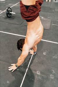 High angle view of man performing handstand at gym