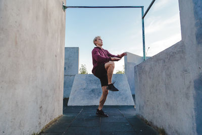 Full length of woman on wall against sky