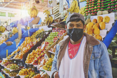 Portrait of a men working in street market - with face mask, public market.