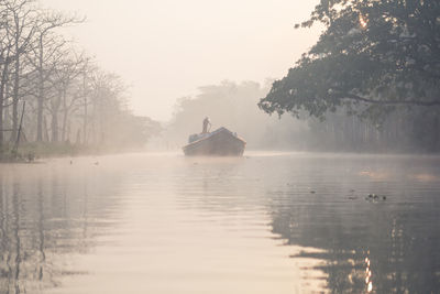 Lonely boat floating on river in haze morning in barisal in bangladesh