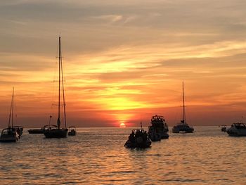 Silhouette of boats in sea during sunset