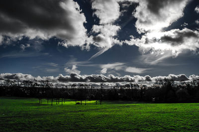 Scenic view of grassy field against cloudy sky