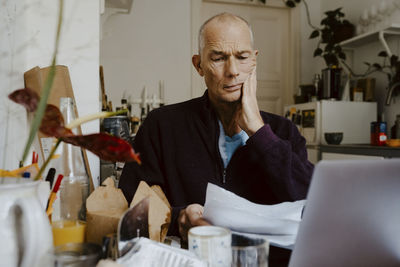 Businessman reading paper document in living room