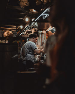 Rear view of people working at bar