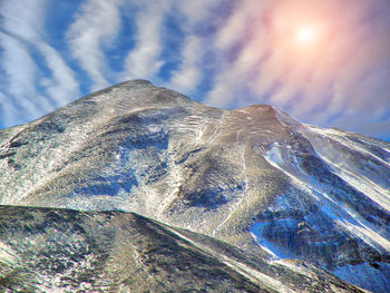 Low angle view of snowcapped mountain against sky