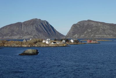 Scenic view of sea and rocks against clear blue sky