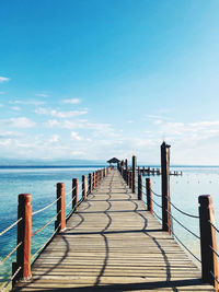 Wooden pier on sea against sky