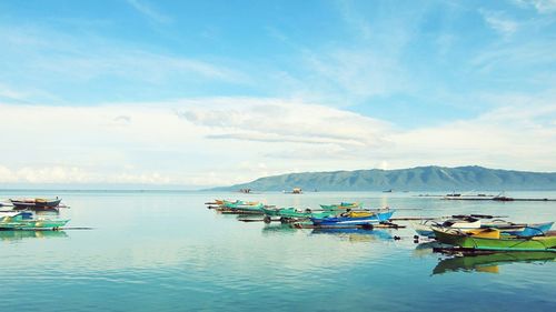 Boats moored in sea against sky