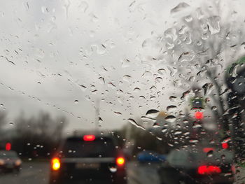 Cars on road seen through wet window in rainy season