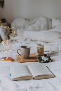 Coffee cup and book on bed at home
