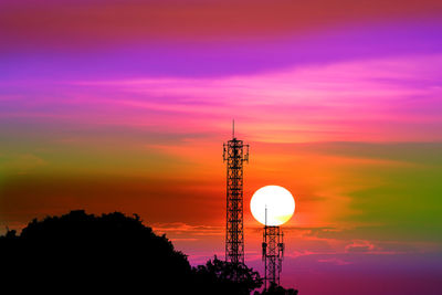 Silhouette tower against orange sky