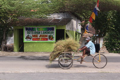 Woman with bicycle on road in city