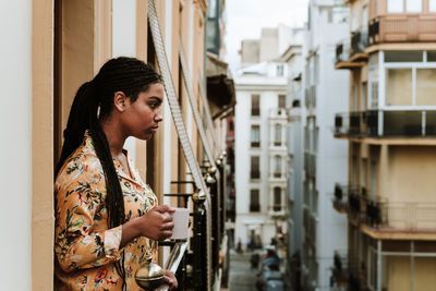 Side view of woman looking at city