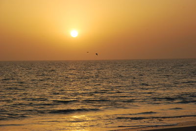 Scenic view of sea against orange sky