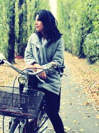 Young woman with bicycle on road during autumn