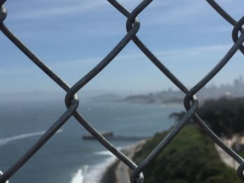 Close-up of chainlink fence against sky