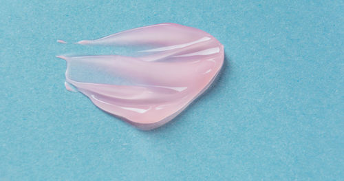 High angle view of pink paper on blue background