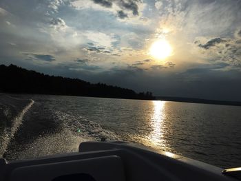 Boats in sea at sunset