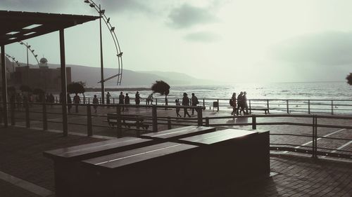 People by sea against sky