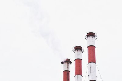 Low angle view of smoke stacks against sky