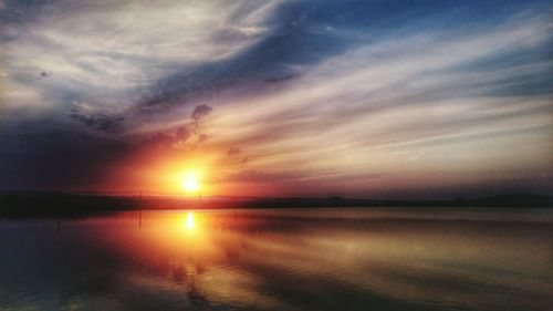 Reflection of clouds in sea at sunset