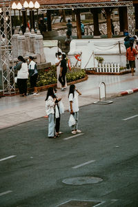 Group of people walking on road in city