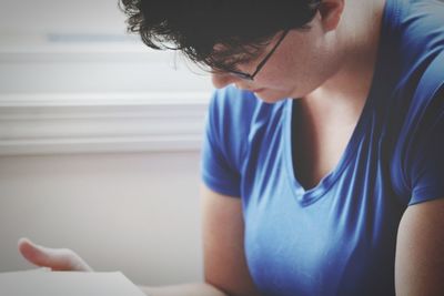 Close-up of woman reading book at home