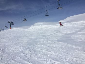Ski lift over snowcapped mountain against sky