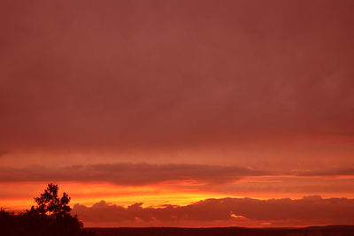 Scenic view of silhouette landscape against orange sky