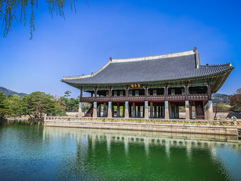 Built structure in lake against blue sky