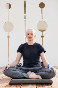 Man practicing yoga on the pier of resort. breathing outdoors. inhale fresh air