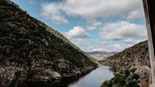Scenic view of river amidst mountains against sky