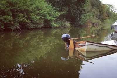 Man in boat on lake against trees in forest