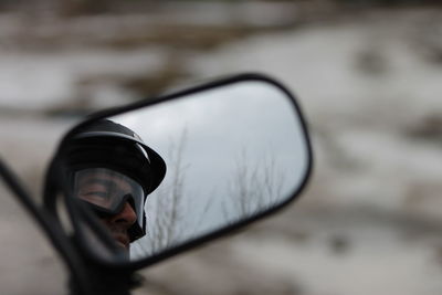 Mid adult man in helmet reflecting in mirror