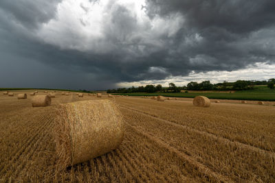 Hay bales on field against sky