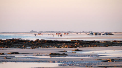 View of people on beach against clear sky