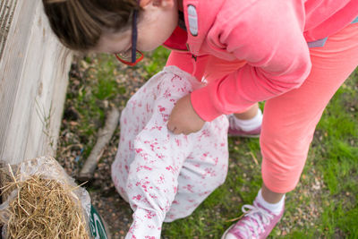 High angle view of girl making scare crow on field