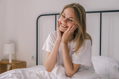 Awakening in the morning. young happy woman smiling and touching her face 