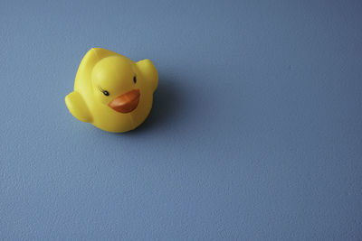 Close-up of yellow toy over blue background