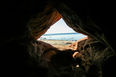 Scenic view of sea seen through cave