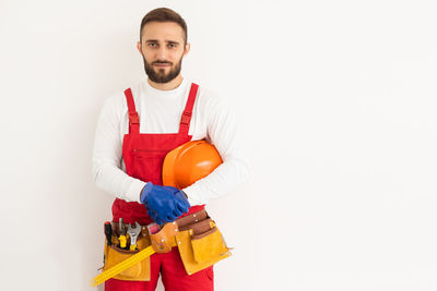 Portrait of man holding gift box against white background