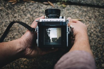 Close-up of cropped hand holding camera