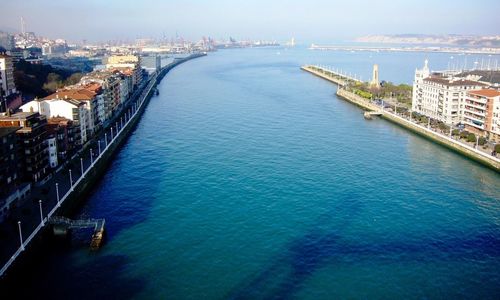 High angle view of town by sea against sky